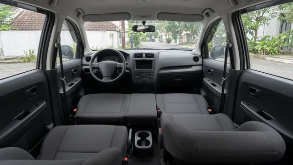Foto interior MPV tujuh penumpang dengan kursi baris ketiga terlipat dan jok kain yang bersih