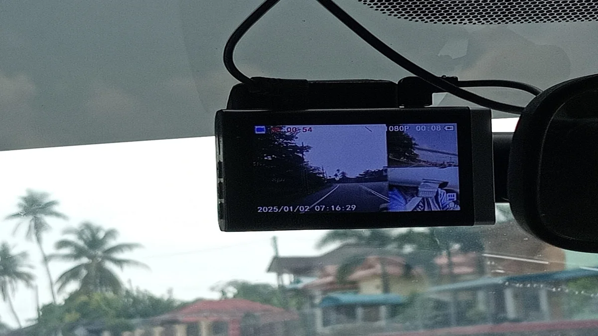 Foto dashcam terpasang di balik spion tengah dengan kabel dirapikan di sepanjang plafon dan pilar kaca
